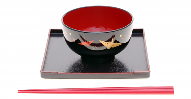 A lacquerware rice bowl featuring an origami crane relief.