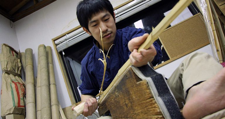 Tozando Shinai craftsman shaving bamboo staves.