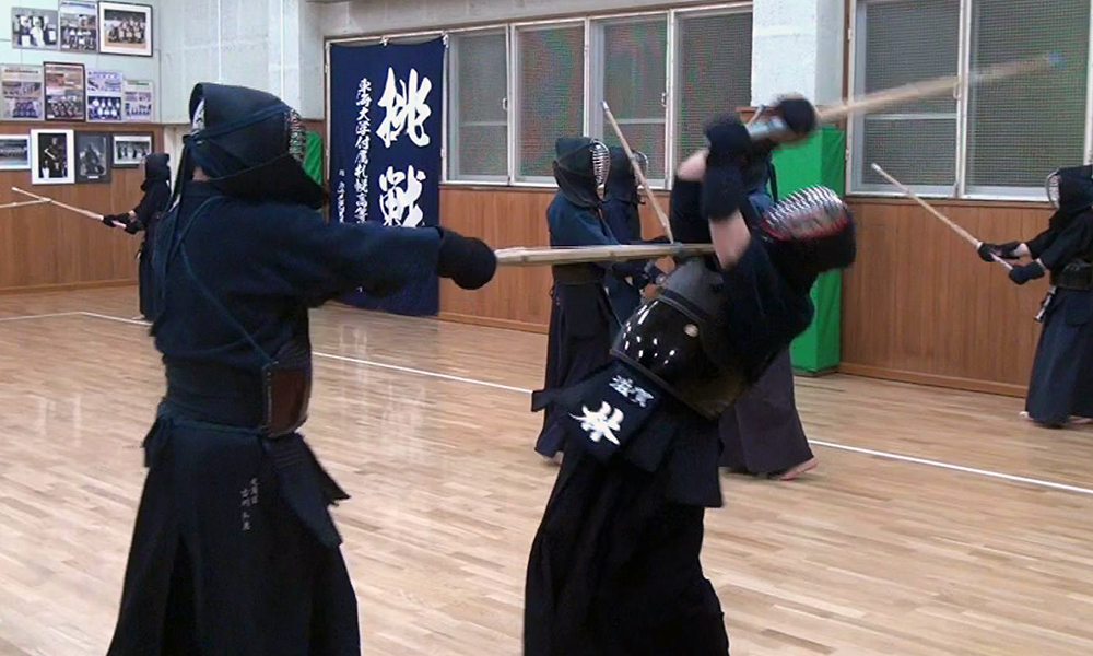 A kendo student receives a powerful thrust to the throat when attempting to strike their teacher.