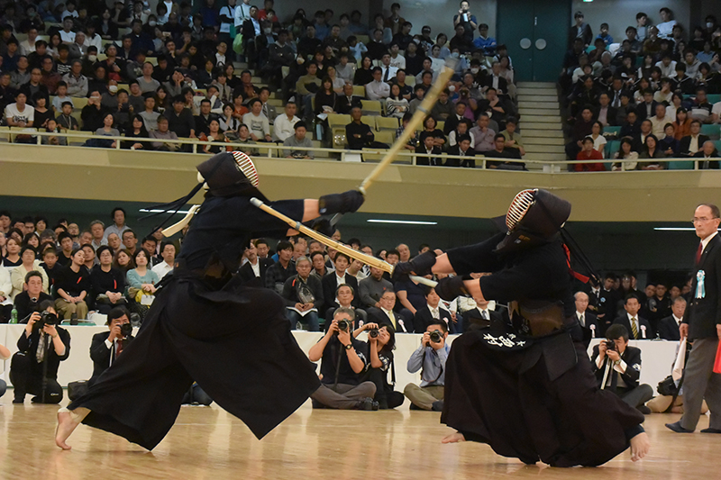 Two kendoka face each other during a shiai; one tries to strike kote and another tries to strike men.