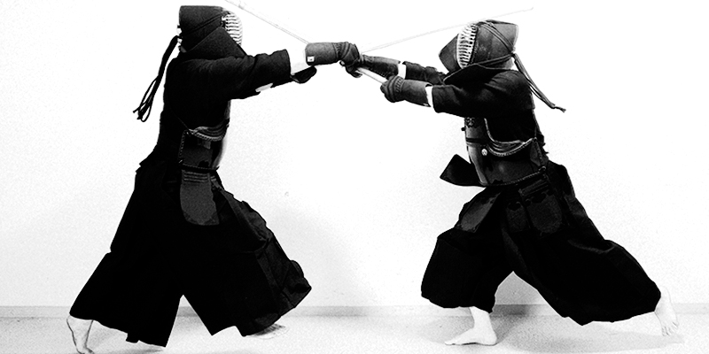 Black and white photo of two Kendo players trying to hit the Men